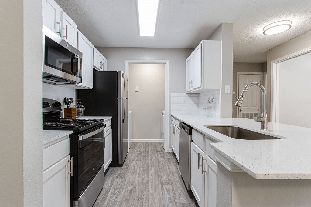 an empty kitchen with white cabinets and black appliances  at Peaks at Gainesville, Gainesville, 30507