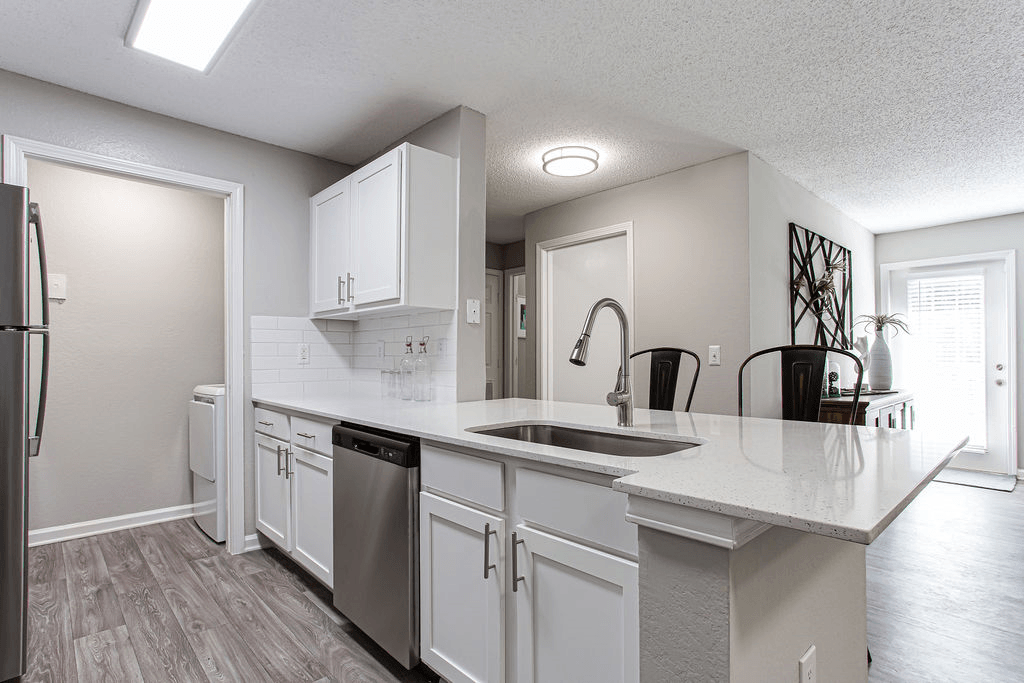 an open kitchen with white cabinets and a large counter top  at Peaks at Gainesville, Gainesville, Georgia