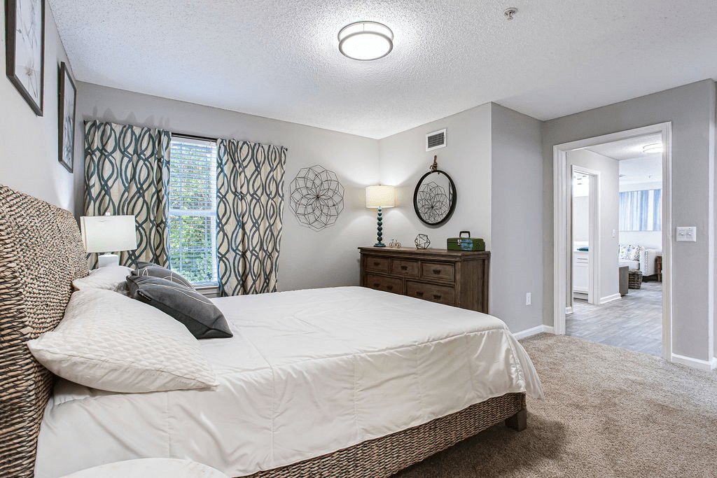 a bedroom with a large bed and a door to a bathroom a bedroom with a large bed and a door to a bathroom at Peaks at Gainesville, Gainesville, Georgia