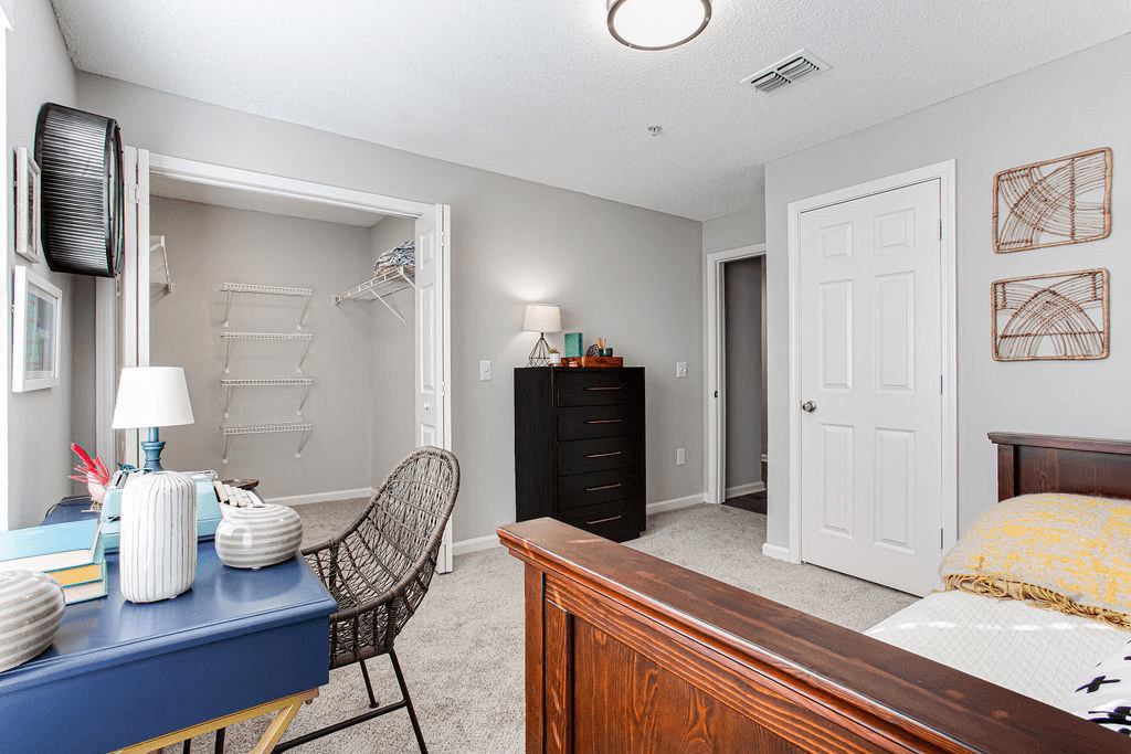 a bedroom with a desk and a bed and a closet  at Peaks at Gainesville, Gainesville, GA, 30507