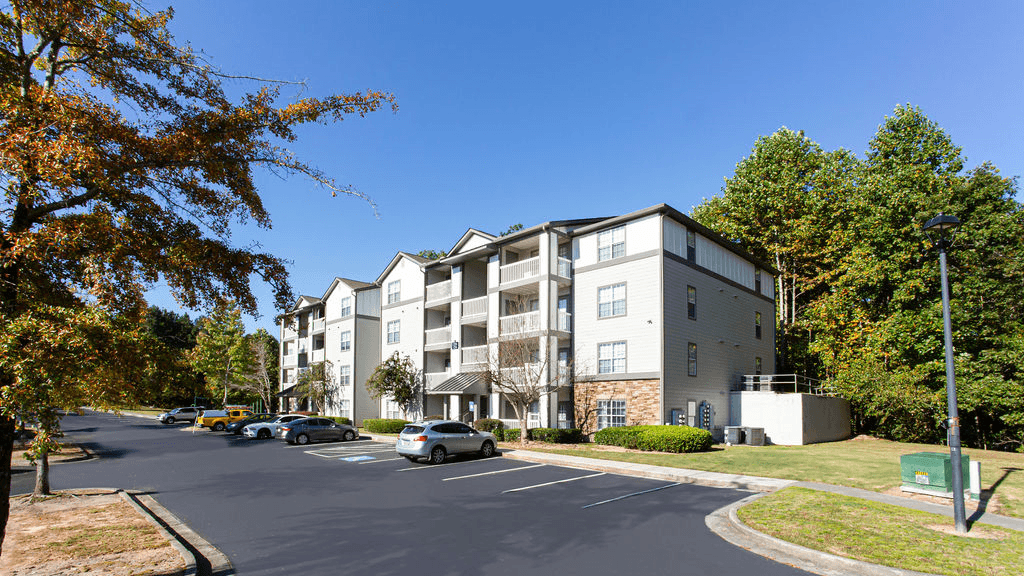 an apartment building on a street with cars parked in front of it  at Peaks at Gainesville, Gainesville, 30507