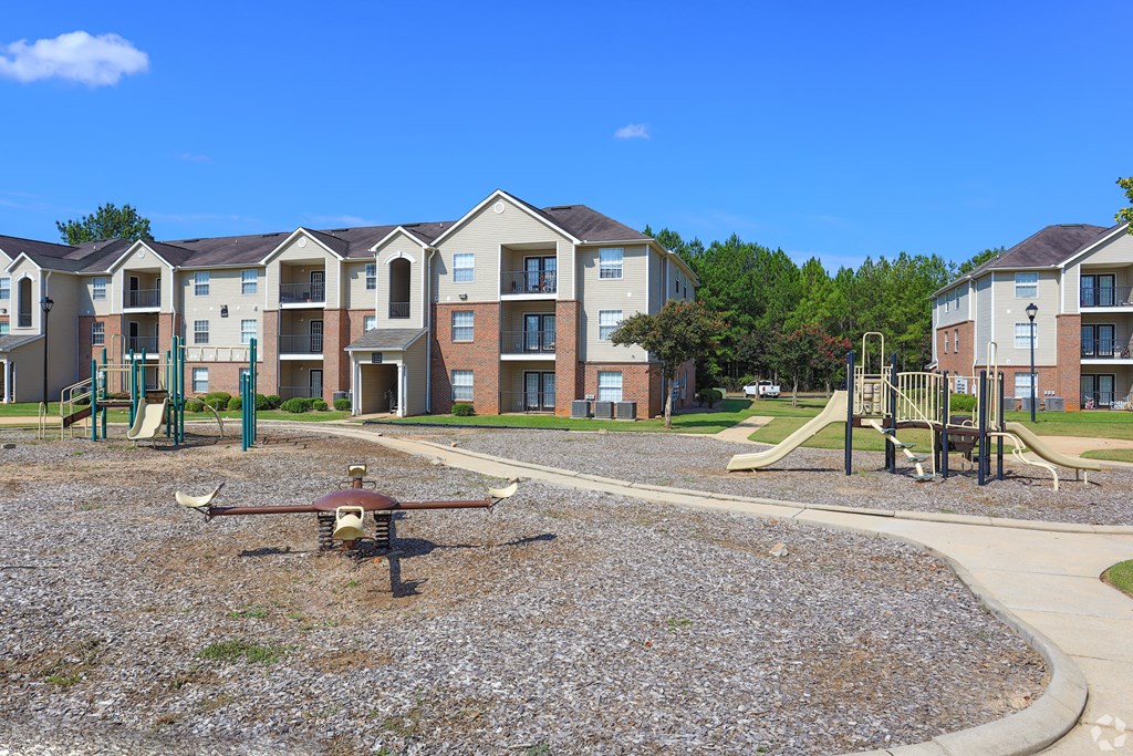 an empty playground in front of an apartment building