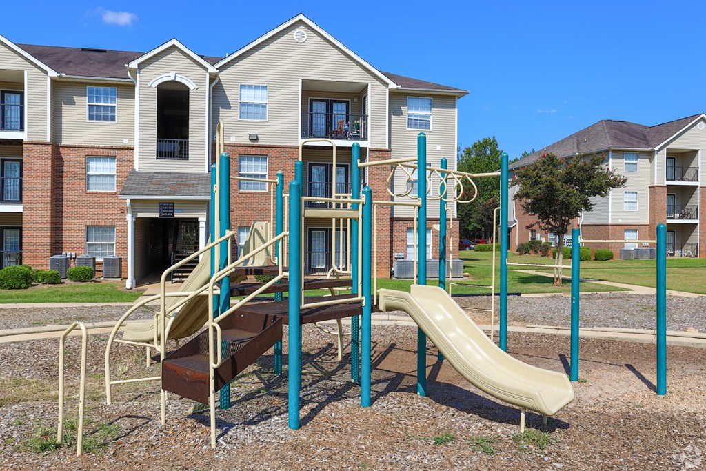 an empty playground in front of an apartment building