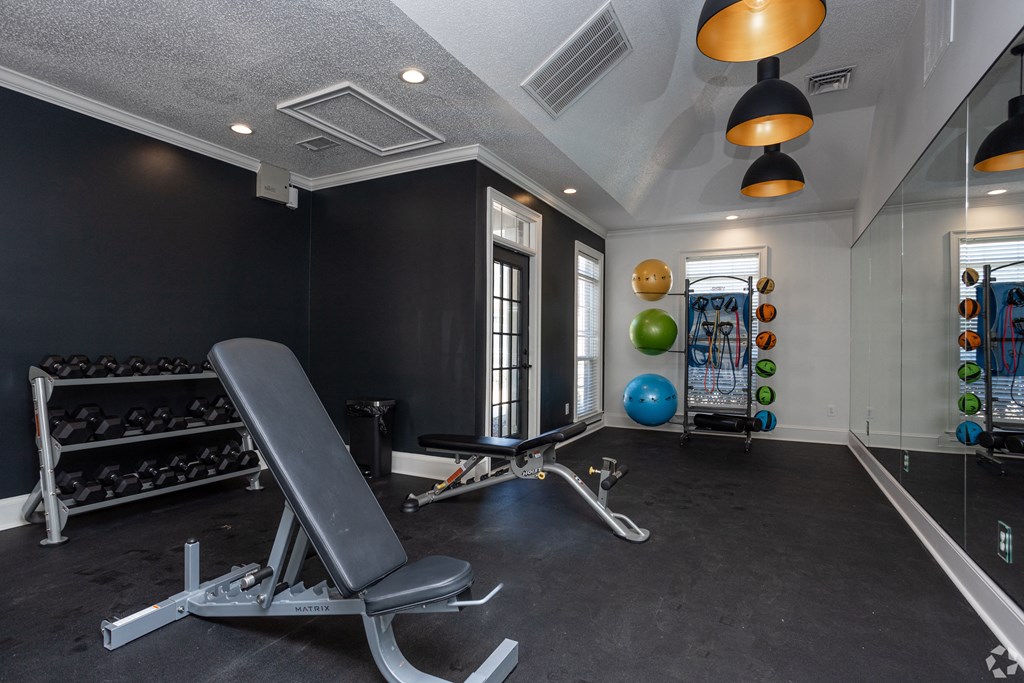 a gym with a workout bench and weights on the floor