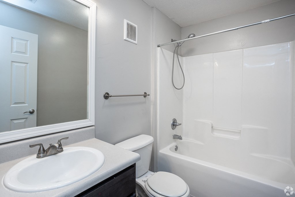 an empty bathroom with a sink toilet and shower