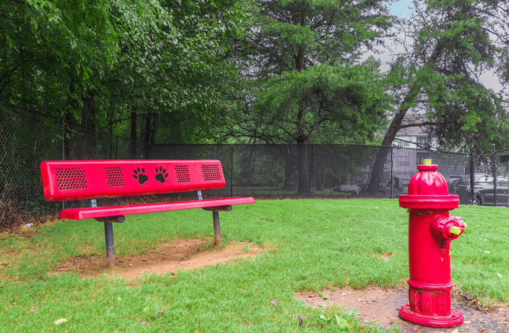 a red bench sitting next to a red fire hydrant