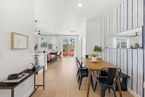 A modern dining room with a wooden table and chairs.