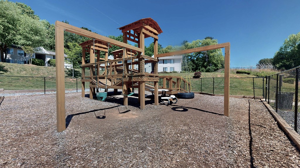 a large playset with a large wooden structure in the middle of a gravel area  at Vue on Medlock, Georgia