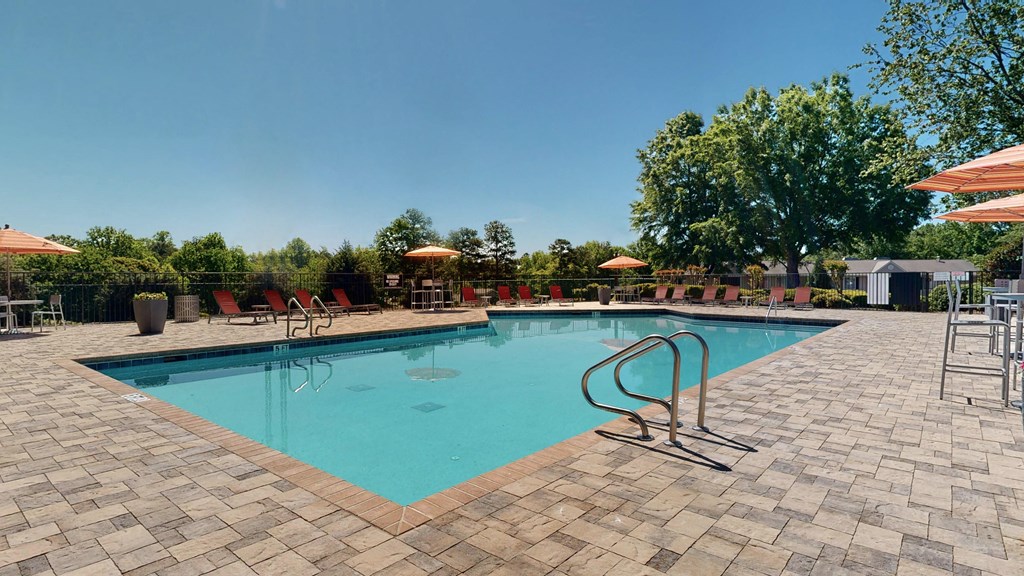 a swimming pool with lounge chairs and umbrellas at Vue on Medlock, Peachtree Corners