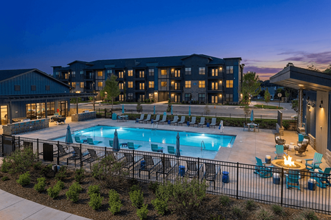 A large building with a pool in front of it.