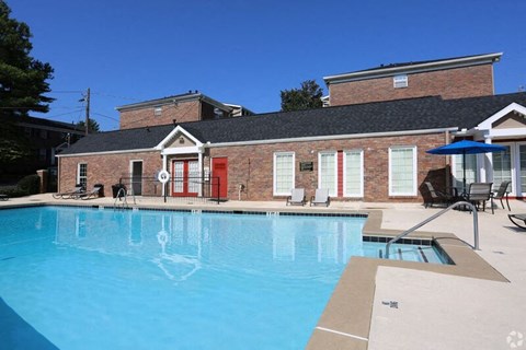 a large swimming pool in front of a brick building