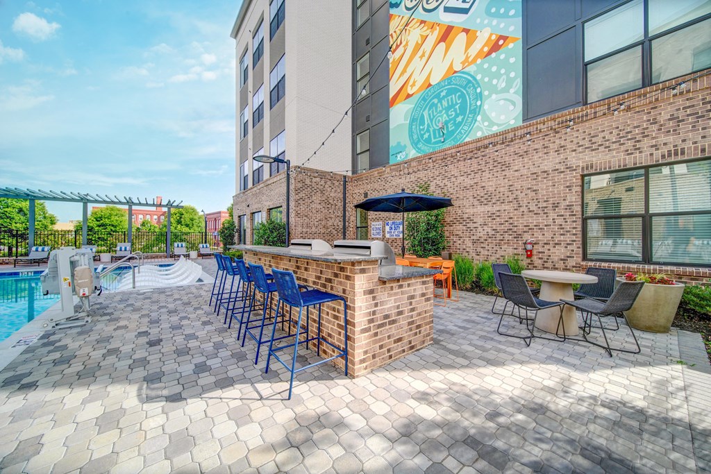 a patio with a bar and a pool at an apartment building