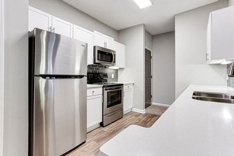 a kitchen with stainless steel appliances and white cabinets