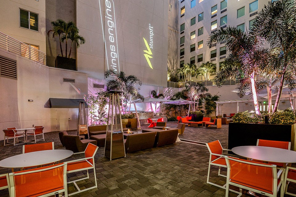a lounge area with tables and chairs in front of a building
