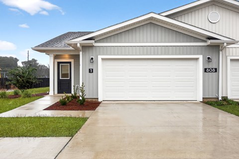 A house with a grey roof and a white garage door.