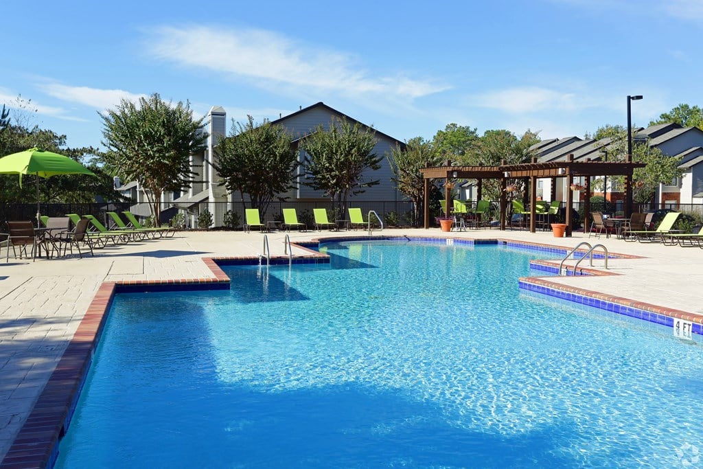 A large swimming pool with a sunny sky in the background.