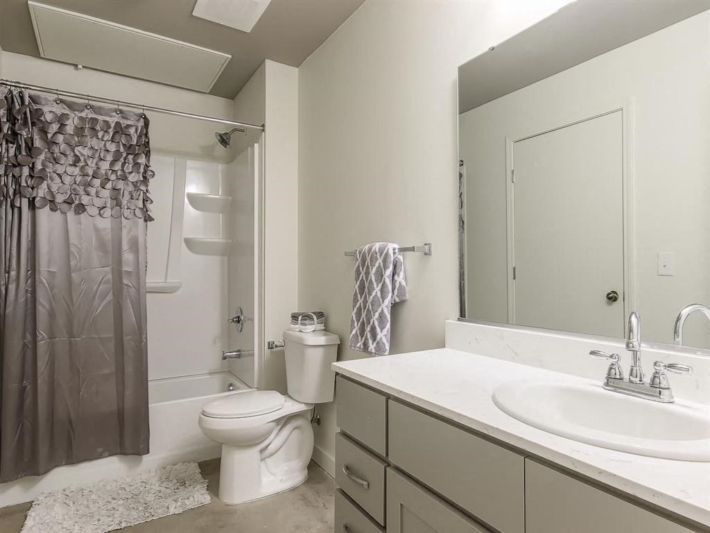 Updated bathroom with grey cabinets and garden tub at Land Bank Lofts in Columbia, SC