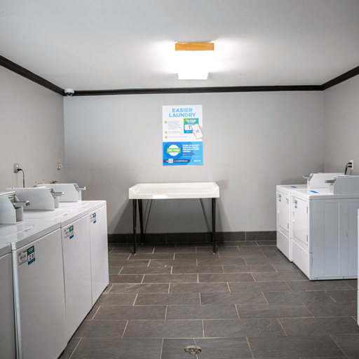 a laundry room with washer and dryers and a white table
