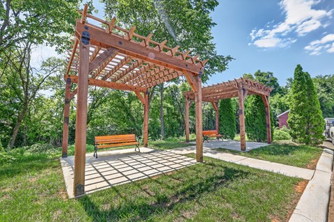 A wooden pergola with a bench underneath it.