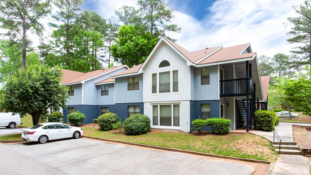 a white and blue house with a car parked in front of it