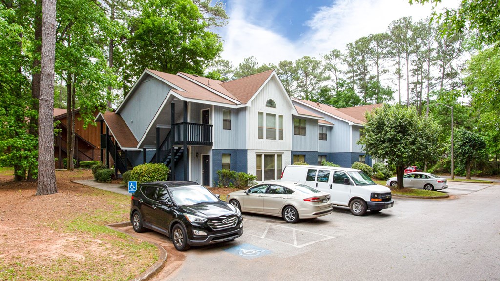 a house with a parking lot and cars in front of it