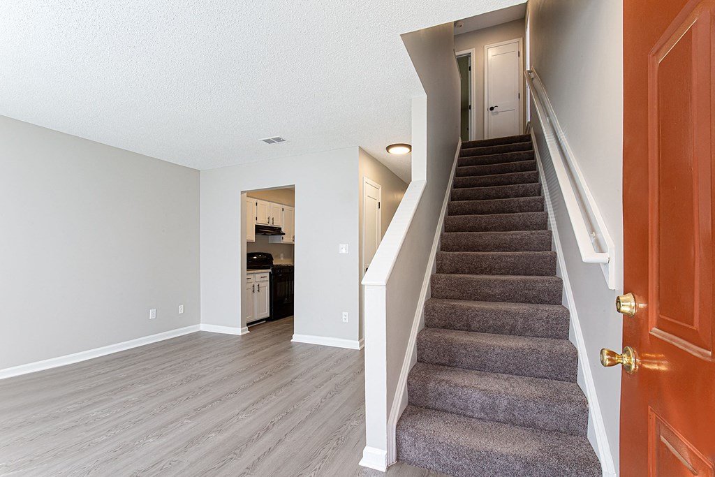 the entryway of a house with stairs and a door