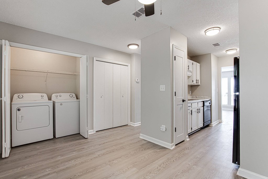 a renovated living room and laundry room with washer and dryer