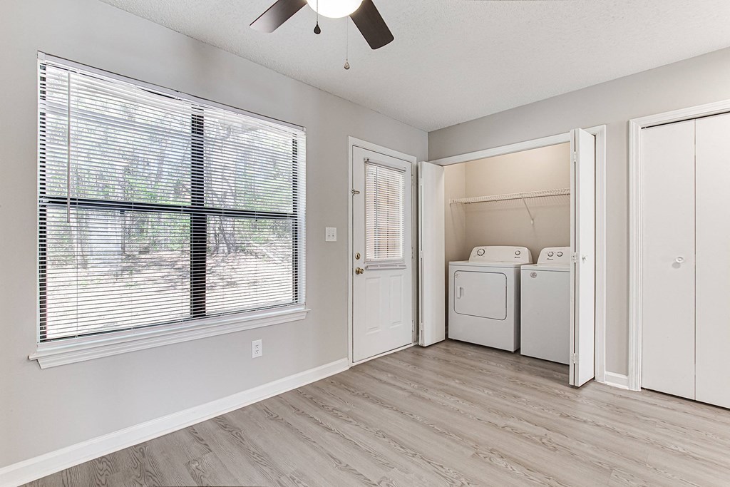 an empty room with a large window and a laundry room