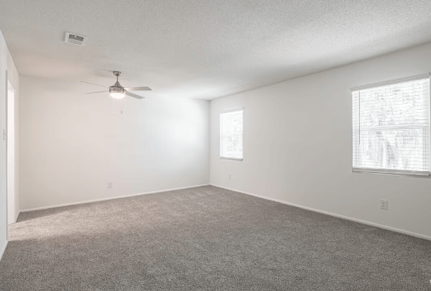 an empty living room with a ceiling fan and a window at Crescent Place Apartments, Georgia, 31419