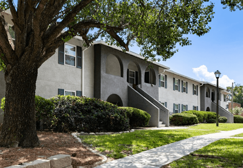 Apartment building with a sidewalk and a tree at Crescent Place Apartment, Savannah