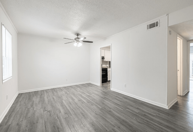 an empty living room with white walls and a ceiling fan at Crescent Place Apartments, Savannah, GA, 31419