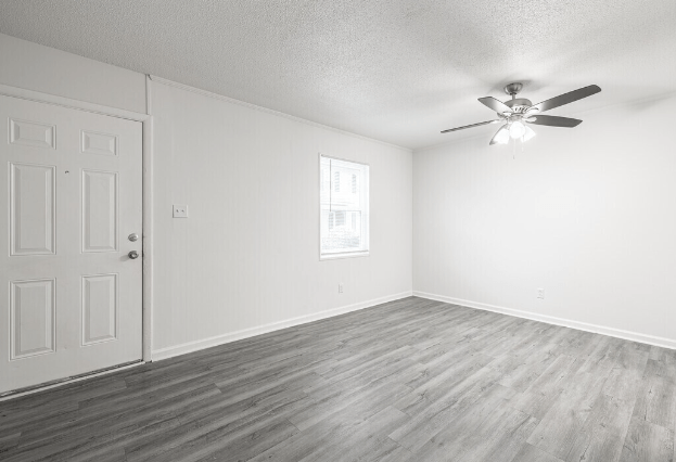 an empty living room with white walls and a ceiling fan at Crescent Place Apartments, Georgia, 31419