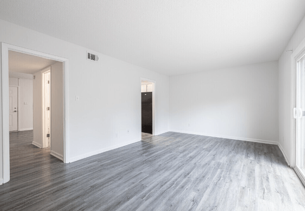 an empty living room with white walls and wood floors at Crescent Place Apartments, Savannah, 31419