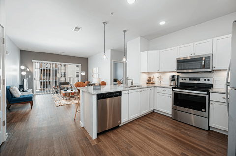 A modern kitchen with white cabinets and stainless steel appliances.