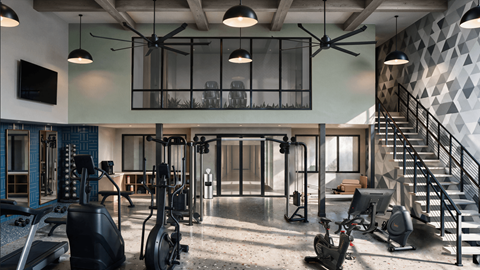 A gym with a variety of equipment including treadmills, weights, and a staircase.