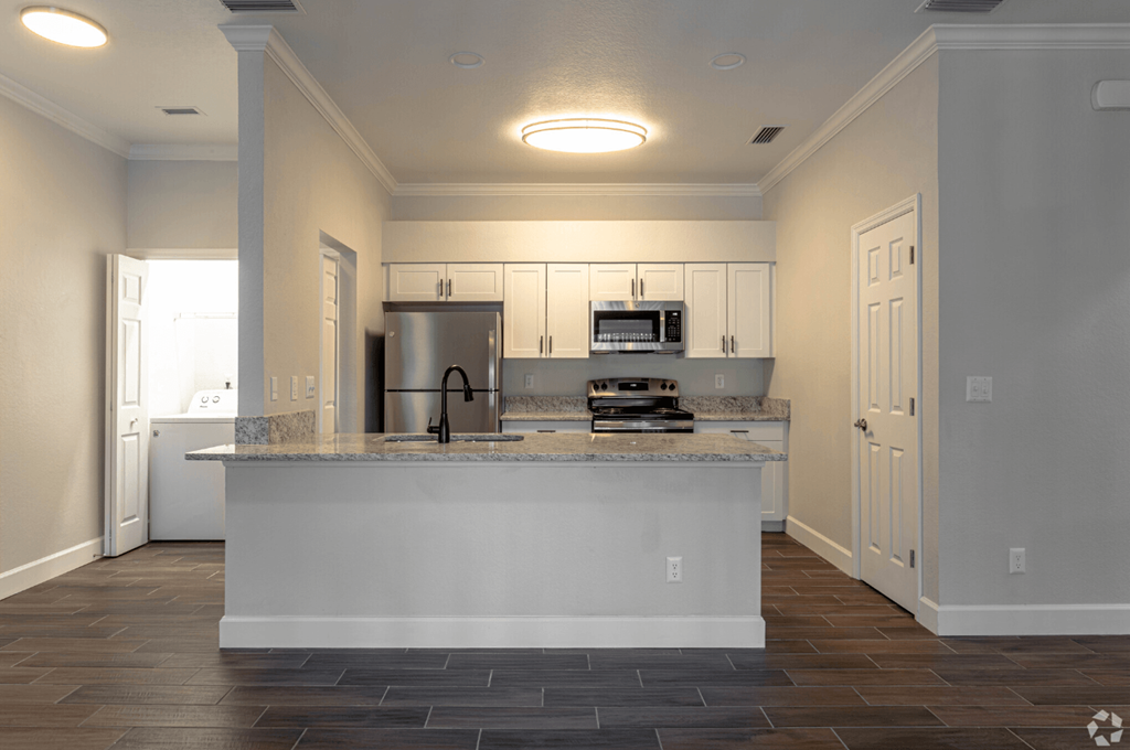 a kitchen with a counter top and a refrigerator a kitchen with a counter top and a refrigerator at Waters Edge Apartments, Lakeland, 33803