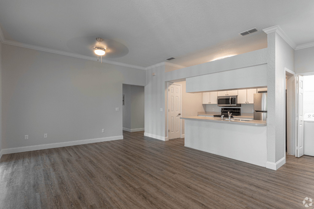 the living room and kitchen of an apartment with a wood floor at Waters Edge Apartments, Lakeland