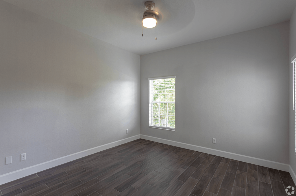 an empty living room with wood floors and a window at Waters Edge Apartments, Lakeland, 33803