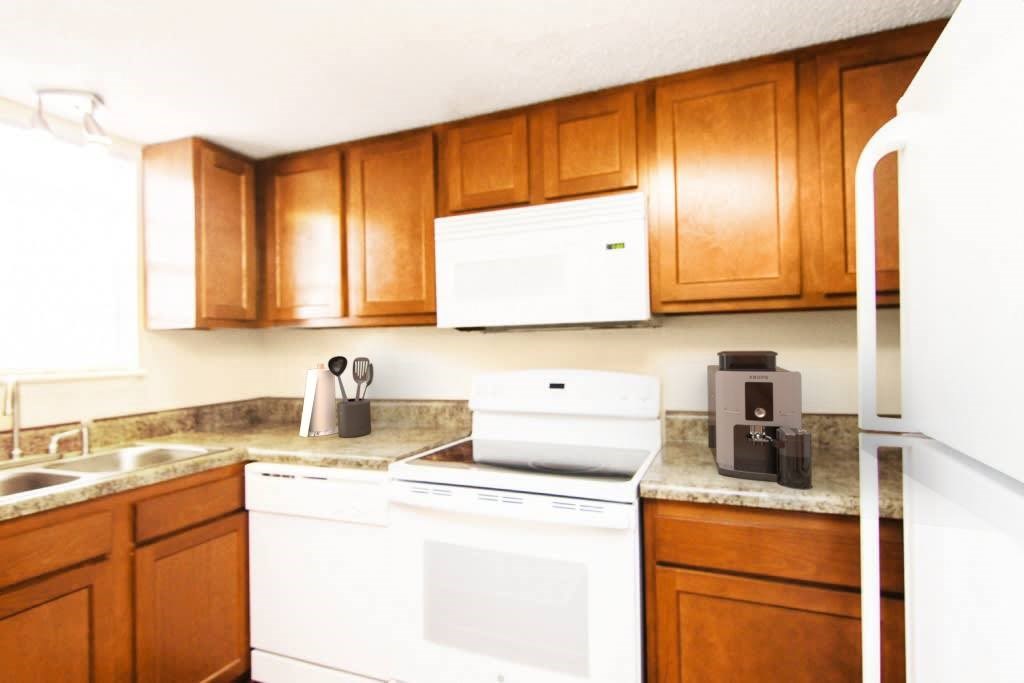 A white oven and microwave are on a counter in a kitchen.