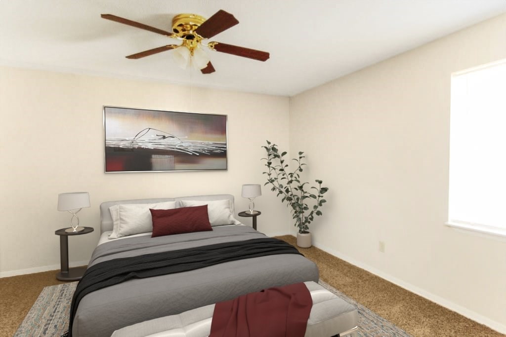 A bedroom with a bed, a ceiling fan, and a painting on the wall.