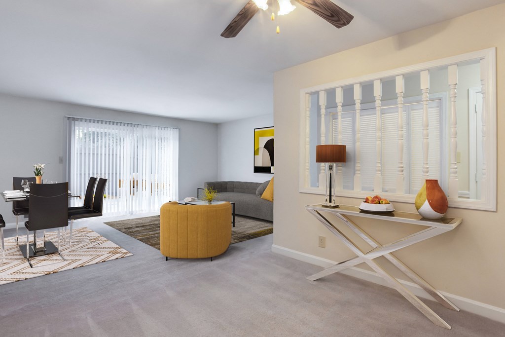 a living room with a ceiling fan and a table with a lamp on it  at The Mason Mills Apartments, Georgia