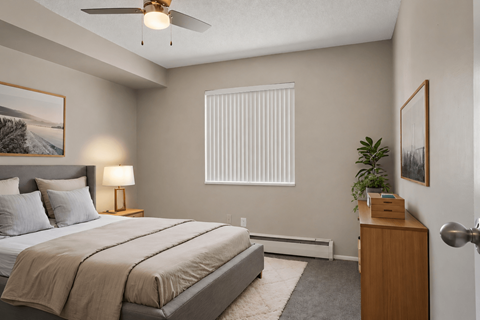 A bedroom with a large bed and a ceiling fan.