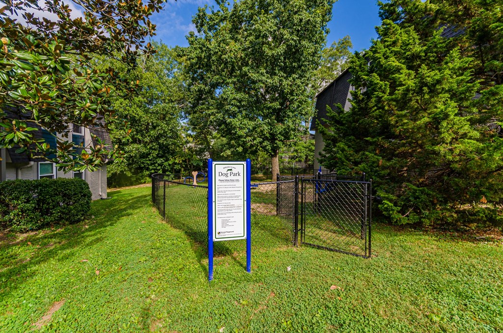 a sign in front of a yard with trees and a building in the background at Summit East Ridge, East Ridge, TN 37412