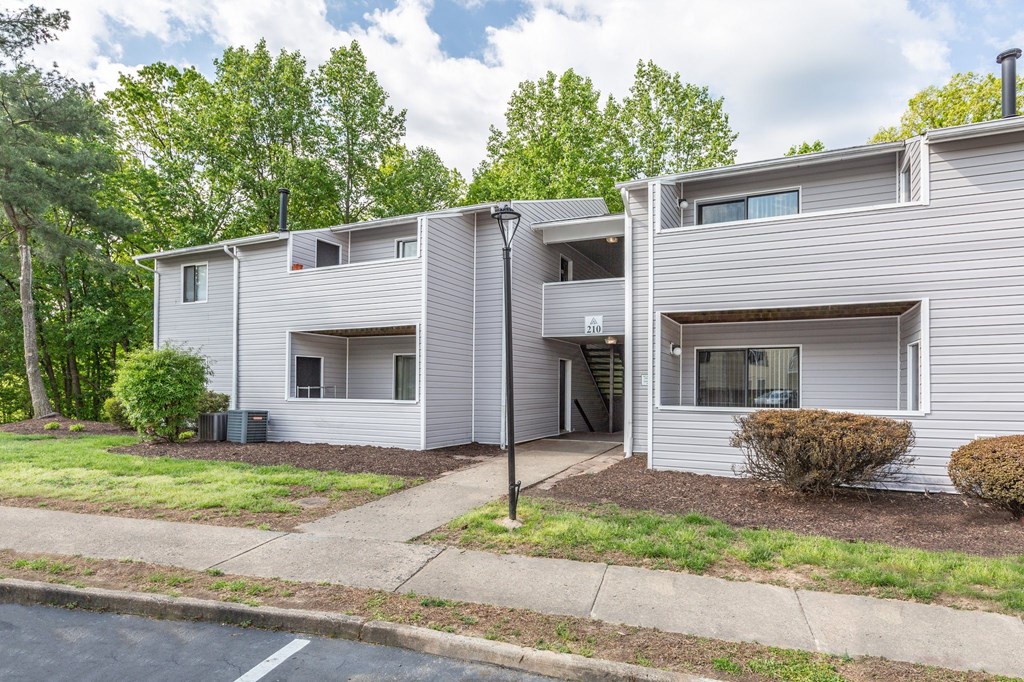 a grey apartment building with trees in the background