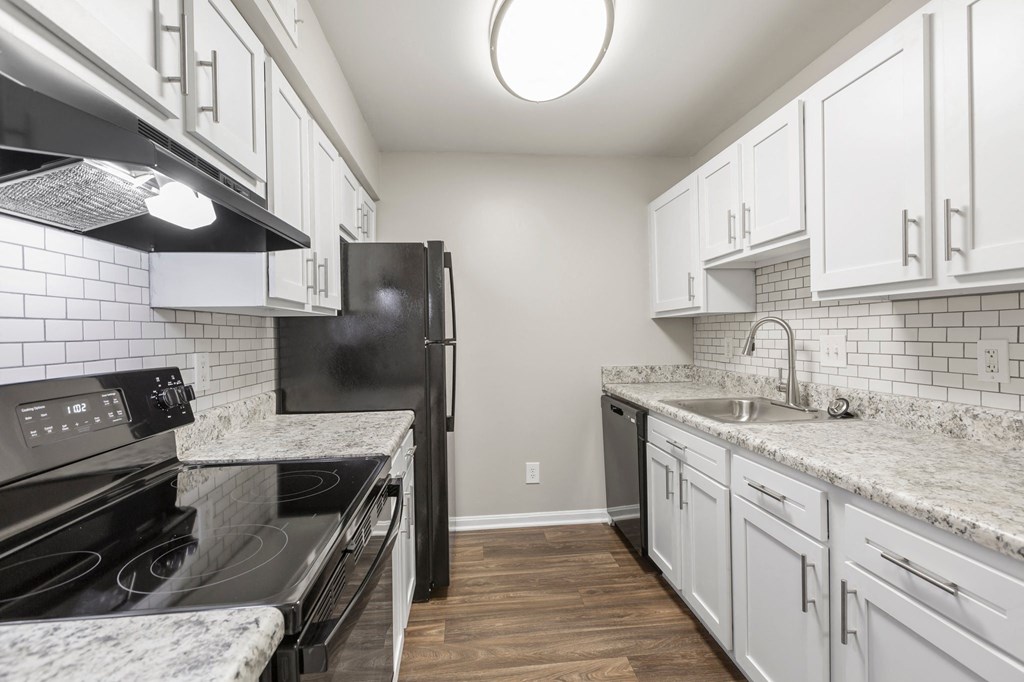 a kitchen with white cabinets and a black stove top oven