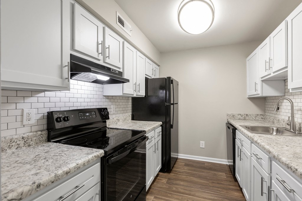 a kitchen with white cabinets and black appliances