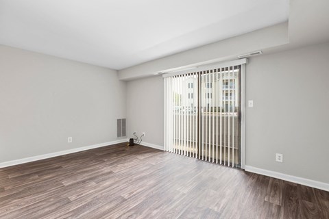 a living room with a sliding glass door and wood flooring