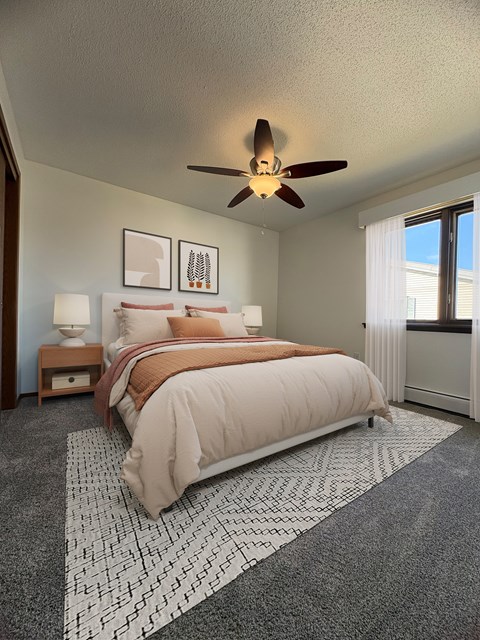 A bedroom with a large bed and a ceiling fan.