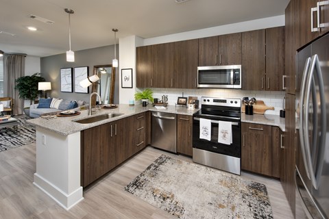 A modern kitchen with dark wood cabinets and stainless steel appliances.