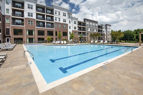 A large swimming pool in front of apartment buildings.